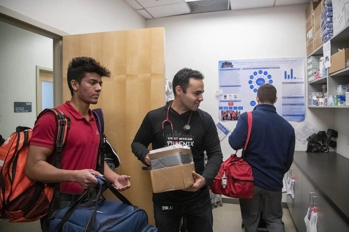 Student volunteer Eashan Das, left, co-founder Jeffery Hanna, center, and co-founder Justin Zeien, right, put away supplies in the Street Medicine Phoenix storage area on College of Medicine – Phoenix campus after the Grace Lutheran Church street run.