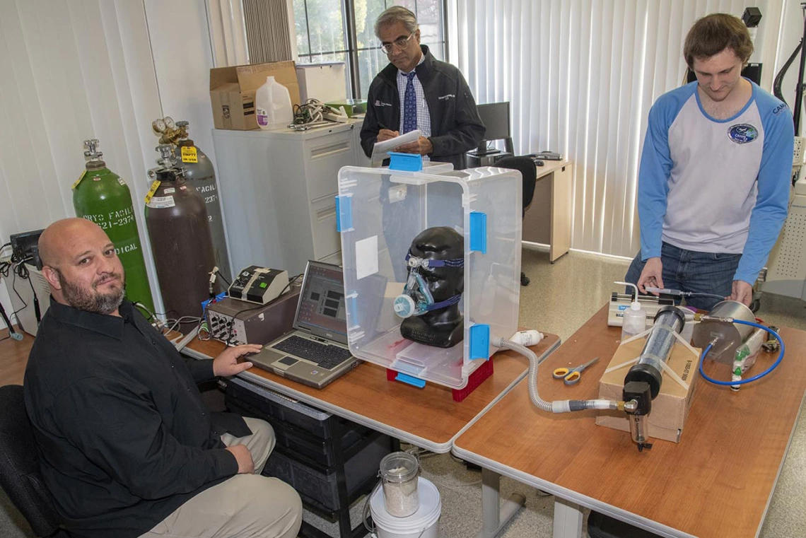 In response to the shortage of PPE, a group of researchers at the University of Arizona College of Engineering and UArizona Health Sciences worked together to design, 3D print and test masks for health care workers at Banner – University Medical Center in Tucson in April. Pictured here: Lab Manager Christopher Morton, left, Sairam Parthasarathy, MD, center, and engineering graduate student Connor Stahl.