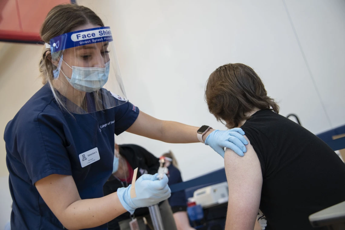 Nursing student Genevieve Veneziale disinfects a student’s arm before administering a flu shot inside NorthREC. Veneziale says she saw several first-time flu-shot recipients at the clinic.