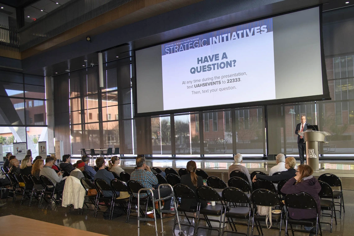 Senior Vice President for Health Sciences Michael D. Dake, MD, invites the audience and people watching the event remotely to text in questions they have for him. 