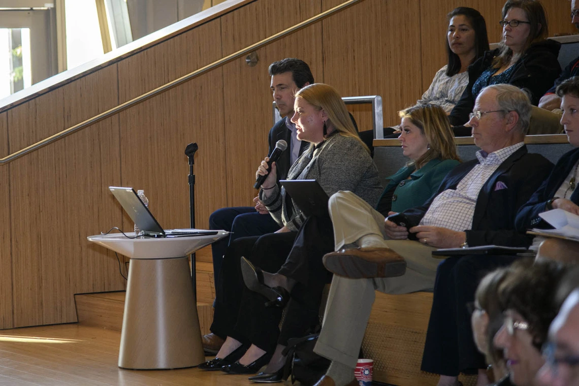 Melissa Colchado, chief of staff of management and policy at the University of Arizona Health Sciences, reads questions sent via text to Senior Vice President for Health Sciences Michael D. Dake, MD.