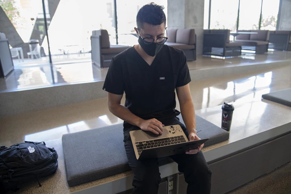 First year College of Medicine – Tucson student Charles Andrew Jauregui checks into Daily Wellness Screening on his laptop before heading to a class. The wellness checks must be completed using the Wildcat WellCheck screening tool, which allows employees and students to self-screen for symptoms before they arrive on campus.