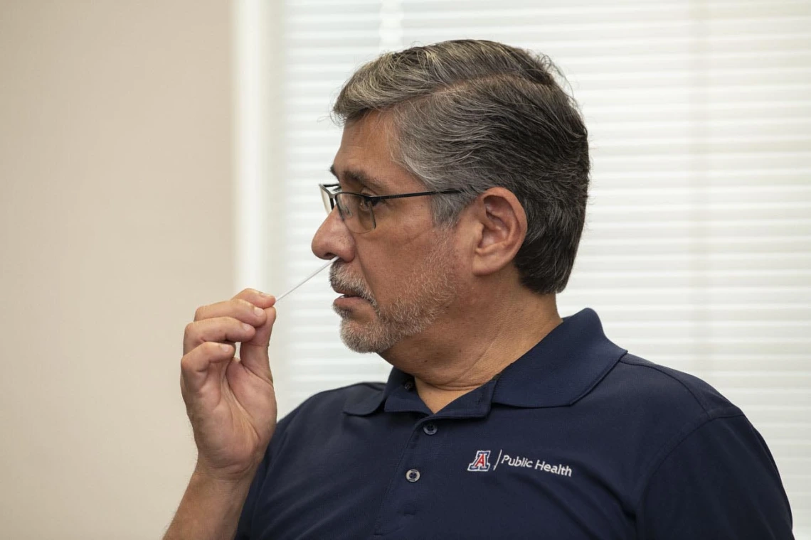 Rodrigo Silva, DVM, MPH, adjunct professor at the Mel & Enid Zuckerman College of Public Health in Phoenix, administers the COVID-19 antigen test by placing a swab inside his nostril to collect a sample. 