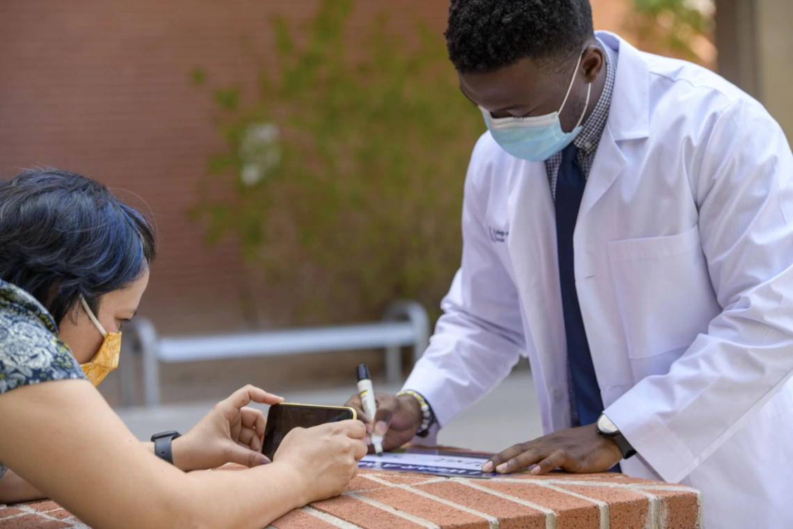 Noelle Haro-Gomez, photojournalist for the Health Sciences Office of Communications, photographs first-year College of Medicine – Tucson student Oluwatobi Faith Odeneye.