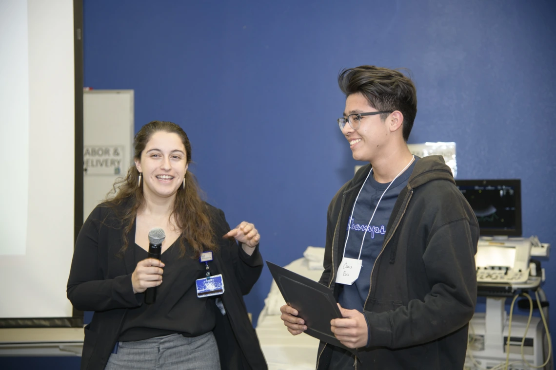 Christopher Ruiz from Sunnyside High School receives a scholarship from a Banner representative.