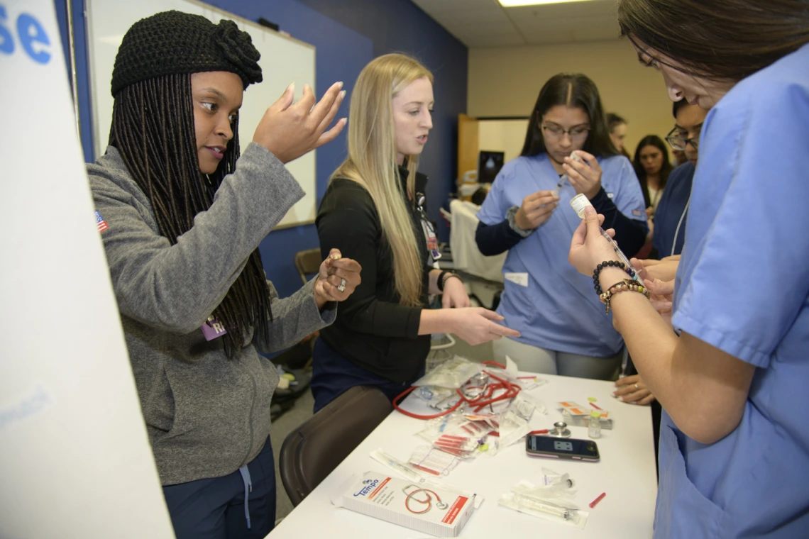 High school students learning about career options in health care visit the nursing booth.