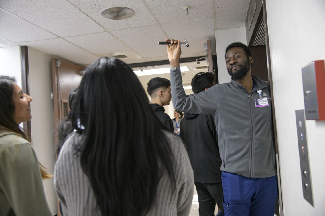 A UArizona College of Medicine - Tucson neurology student asks the tour group what they know about the tool in his hand.