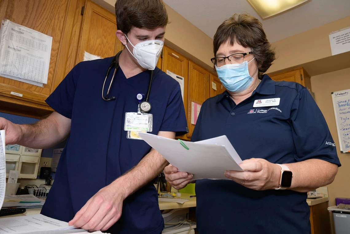 Judith Hunt, MD, and medical student Jeremy Winkleman review charts. 