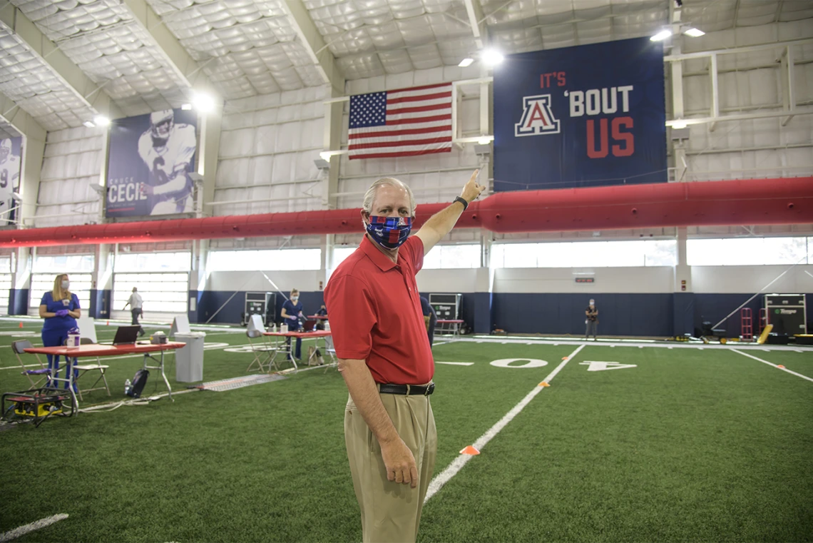 University of Arizona President Robert Robbins, MD, points to a University of Arizona sign as he waits to take the COVID-19 antibody test on April 30, 2020.