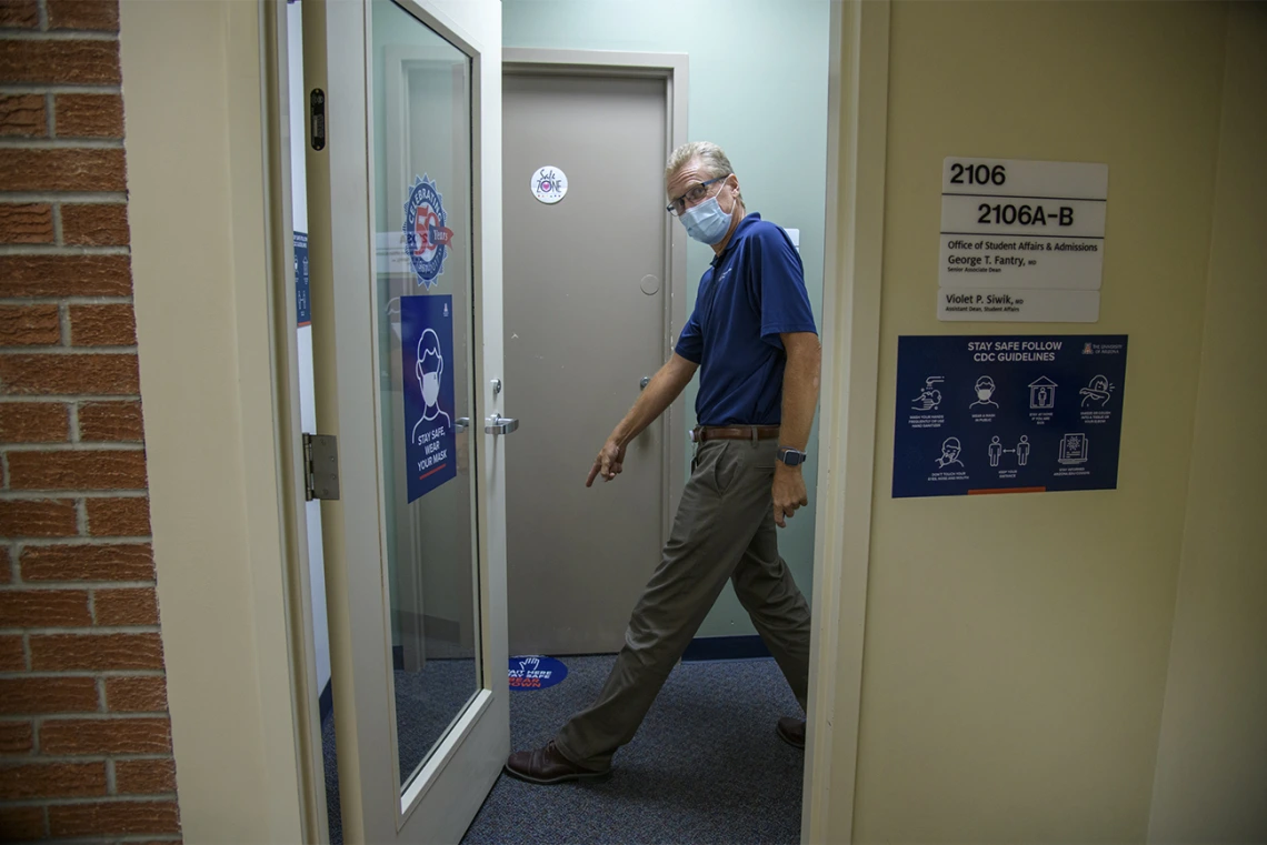 George Fantry, MD, senior associate dean in the College of Medicine – Tucson points to new signage to help people keep appropriate distance.