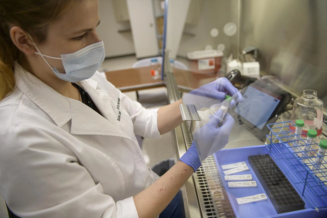 Anete Milkovica, a research technician, opens a test sample. 