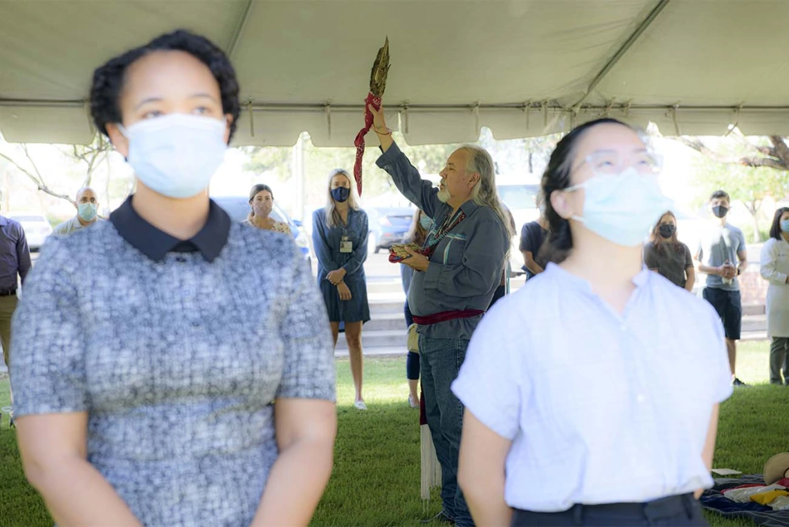 Participants in the Blessing of the Seven Sacred Directions ceremony turn to face west as Dr. Carlos Gonzales leads the blessing. 