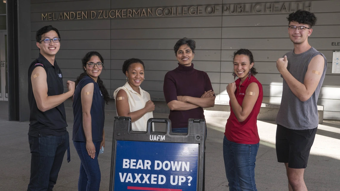 Members of the Alliance for Vaccine Literacy group started by Purnima Madhivanan, PhD, MBBS, MPH,  (center arms crossed) flex their muscles in supporting the UArizona Health Sciences community in effectively talking with vaccine hesitant friends and family. (From left) Students Wesley Chiu, Himanashi Kapoor, Dametreea Carr McCuin, Dr. Madhivanan, Maiya Block, MPH, and Riley Sena.