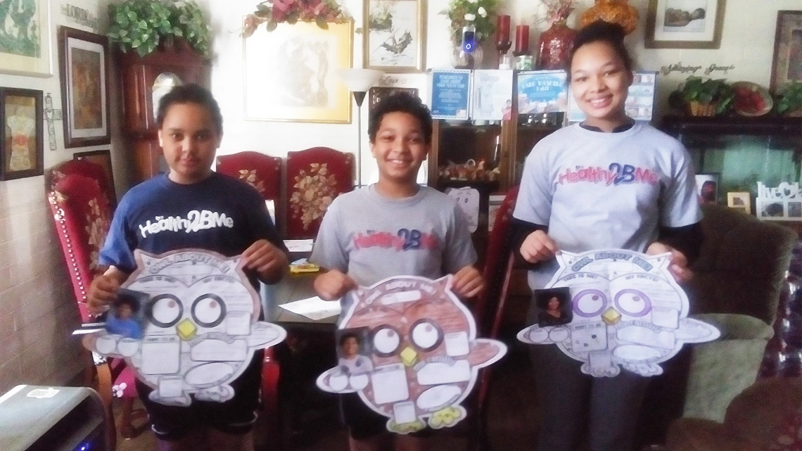 Siblings from the White family show off one of their camp projects.