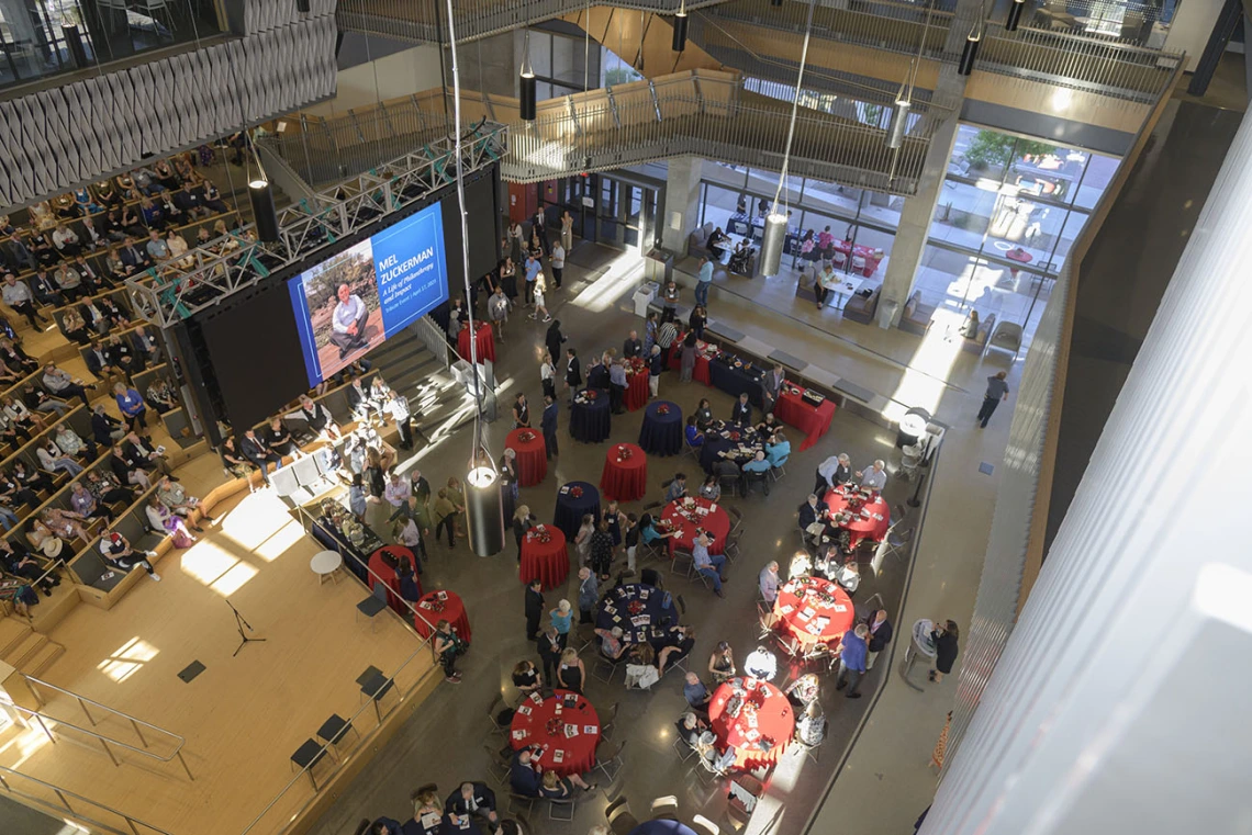 Looking down from above at the crowd gathered for the Mel Zuckerman memorial inside a large open space.