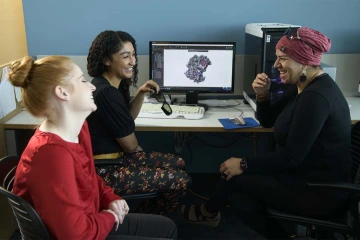 Jaesa Strong holds a pair of 3D glasses, which help visualize drug targets on a computer monitor.