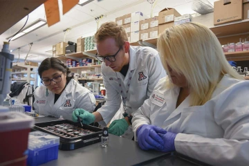 Diné College students Alyssa Joe (left) and Angel Leslie (right) work with graduate student David Bradford on an ALS focused investigation at the UArizona Health Sciences Center for Innovation in Brain Science.