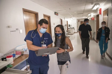 Lily Nguyen (derecha), un estudiante de medicina de segundo año que se desempeñó como coordinadora principal de la clínica durante el semestre de otoño, discute un caso con Díaz. Nguyen dice que la Clínica Familiar Shubitz le brindó una experiencia práctica que algún día podría ayudarla a abrir su propia consulta.