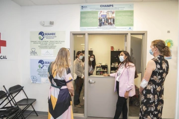 Lisa Kiser, the faculty leader of the MILAGRO Collaborative, speaks with the associate director of Casa Alitas, Susan Selig, and visiting scholar Angela Dawson next to a half door inside Casa Alitas.