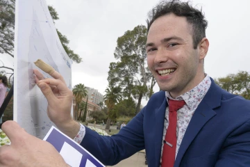 medical student Gregory Branigan places a pin on a Match Day map to indicate where he matched for residency training