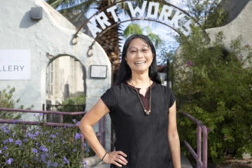 Yumi Shirai, PhD, stands outside the ArtWorks facility with its sign in the background.