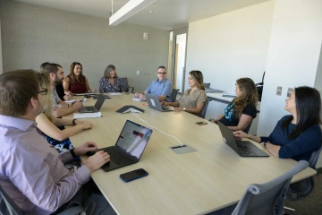  U of A Health Sciences faculty and staff members meet in a conference room