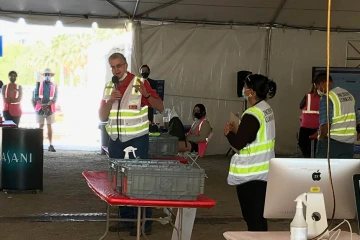 Dr. Mona Arora (center) with Chris Kopach (left), head of the UArizona COVID-19 Incident Command Team and her co-chair of the university’s vaccine task force, give instructions to volunteers at the start of a shift for the UArizona point-of-distribution (POD) clinic. (Courtesy Mona Arora, PhD, MSPH)