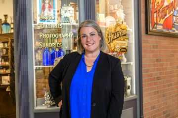 Alexis Peregoy stands in front of the Disneyland Upjohn Pharmacy collection in the renovated Coit Museum of Pharmacy and Health Sciences.