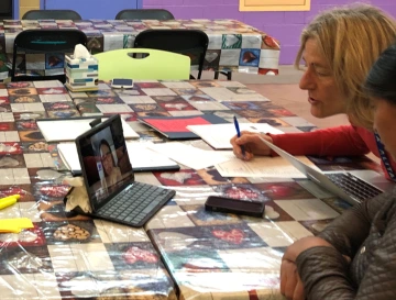 DNP-FNP student Adriana Warne (on screen) conducts a remote wellness check with Guatemalan client and an interpreter.