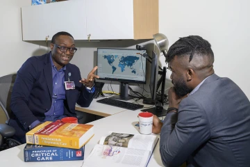 Two men sitting in an office and talking.