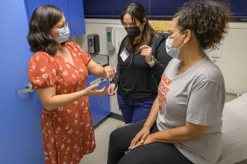 Dr. Zapién (left) provides instruction to volunteers who support the physicians at Clinica Amistad.