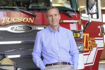 Man standing in front of a fire truck.