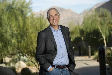 outdoor portrait of man with grey hair wearing business jacket