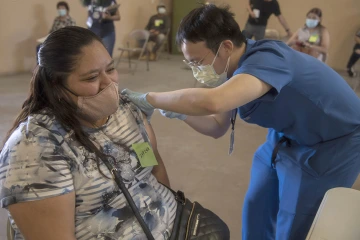 Alvin Wong, DO, a clinical associate professor with the College of Medicine – Phoenix, administers a COVID-19 vaccine to a patient at the community center in Aguila, Arizona, a rural agricultural community west of Phoenix in Maricopa County. The clinic was part of a MOVE UP event hosted by UArizona Health Sciences.