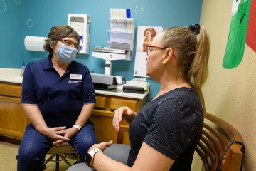 As a rural physician, Dr. Hunt sees patients ranging from newborns to 100 years old. Here, she speaks with patient Tammy Walp in the clinic.