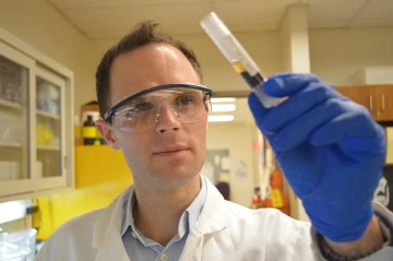 Tad Pace, PhD, pictured here with a vial of blood, runs a research lab at the College of Nursing. He will analyze saliva for cortisol to gauge stress levels in See Me Serene study participants.