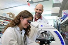 Drs. Rachel Rowe and Jonathan Lifshitz (right) examine specimens in the lab.