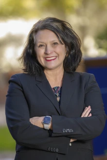 Portrait of Dr. Sheila Gephart standing outside with her arms crossed and smiling. 