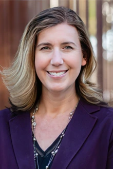 Portrait of a smiling white woman with should-length blonde and brown hair.