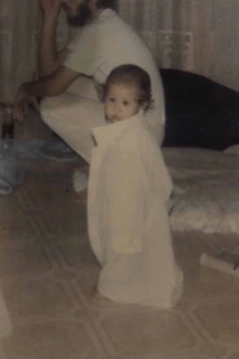 A toddler dressed in a white medical coat