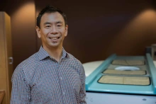 Portrait of Alan Chaing in front of a prototype of the University of Arizona Health Sciences’ noncompression breast CT scanner.