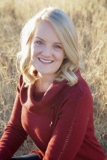 Portrait of Ashley Lowe, PhD, in a sunny, outdoor setting.