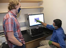 Graduate student and co-author Tyler Ripperger and associate professor Deepta Battacharya, PhD, discuss viral assay results. (Photo: University of Arizona Health Sciences, Noelle Haro-Gomez)